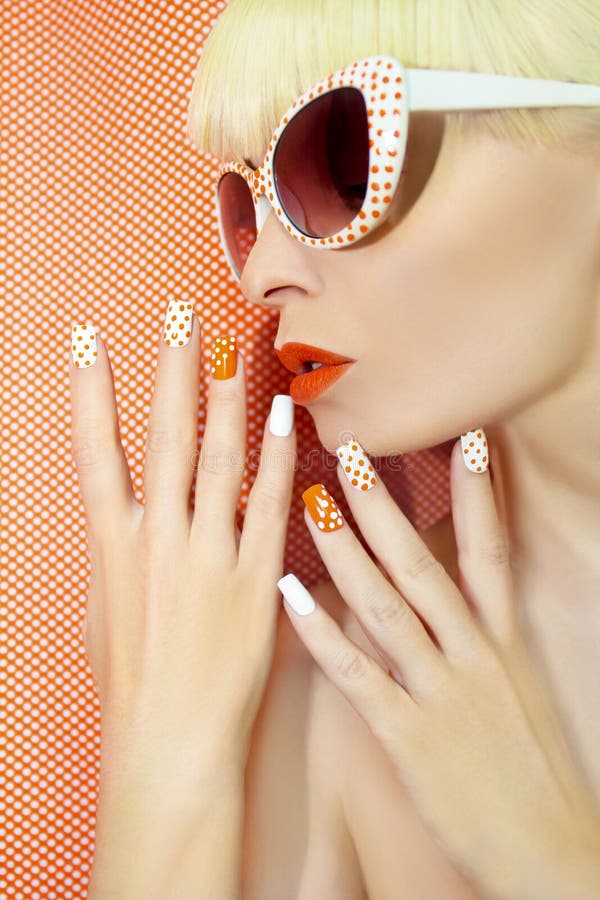 Zonnige oranje manicure en make-up stock afbeeldingen