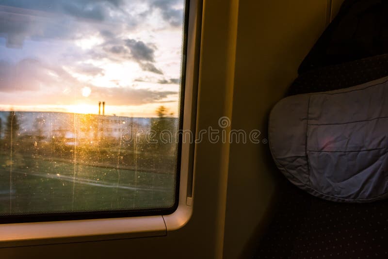 Zonsondergang door de Landbouwgrond van de Passagiersseat van het Treinvenster in openlucht stock foto Zonsondergang door de Landbouwgrond van de Passagiersseat van het Treinvenster in openlucht stock foto