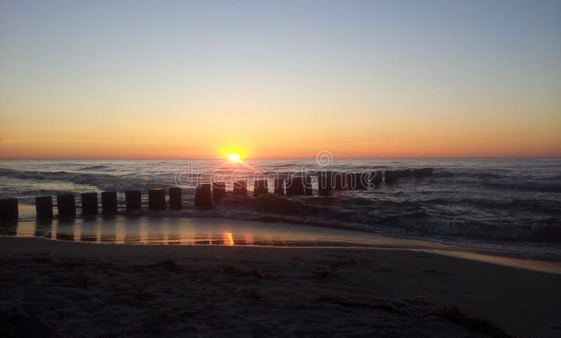 Zonsondergang met golfbreker door de Oostzee stock foto Zonsondergang met golfbreker door de Oostzee stock foto