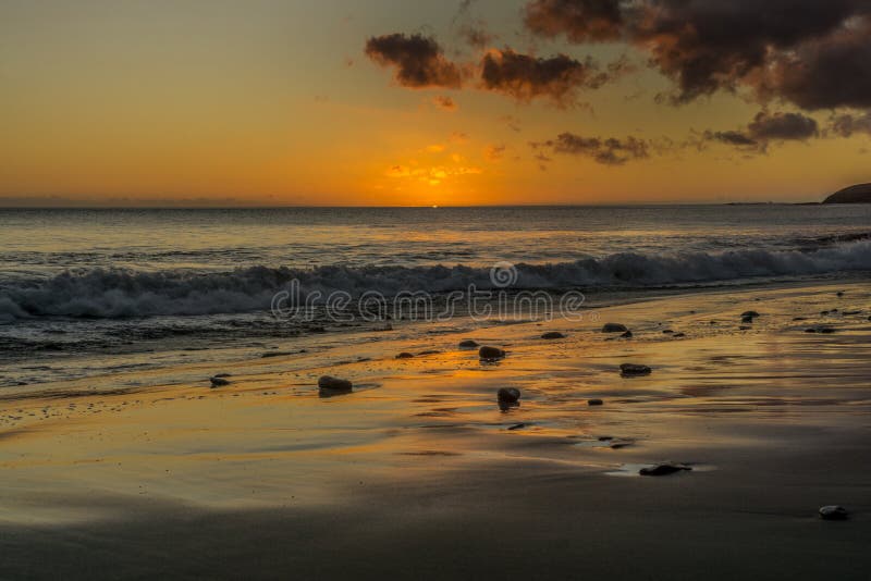 Zonsondergang op het strand van Fuerteventura met lavarotsen royalty-vrije stock foto Zonsondergang op het strand van Fuerteventura met lavarotsen royalty-vrije stock foto