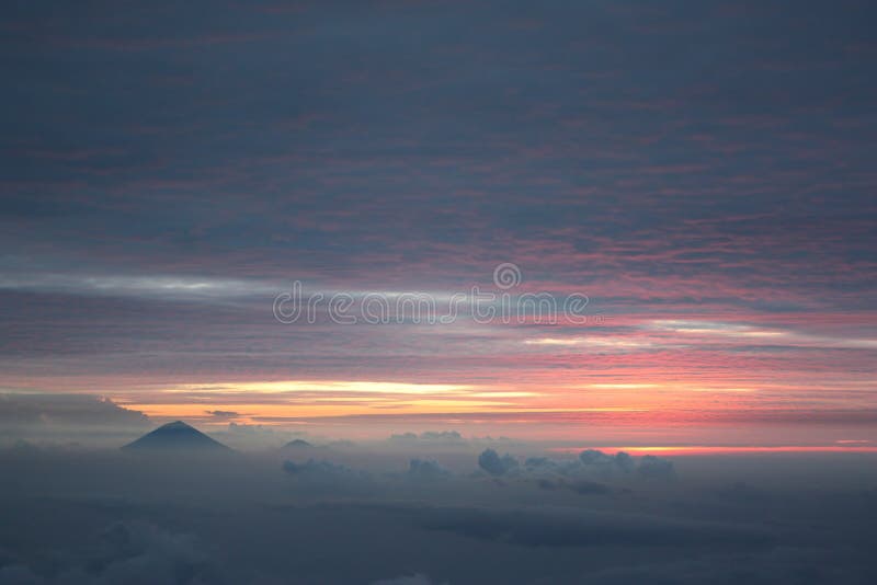 Zonsondergang over vulcano van Gunung Agung in Bali, zoals die van Gunung Rinjani in Lombok wordt gezien royalty-vrije stock foto's Zonsondergang over vulcano van Gunung Agung in Bali, zoals die van Gunung Rinjani in Lombok wordt gezien royalty-vrije stock foto's