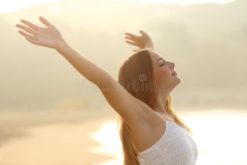 Zrelaksowane kobiety oddychania świeżego powietrza dźwigania ręki przy wschodem słońca