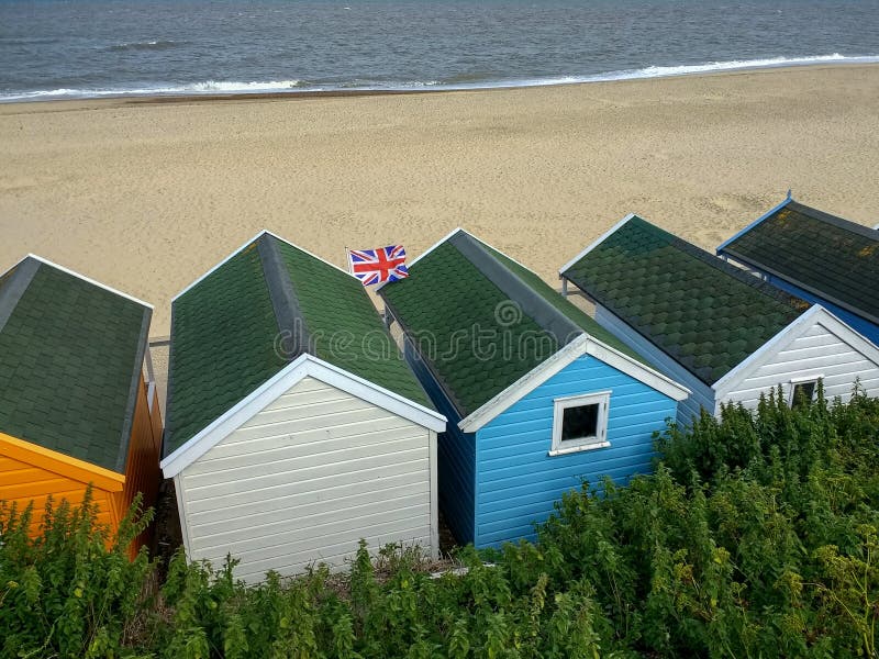 Zrzeszeniowej dźwigarki flaga lata nad plażowymi budami w Southwold, Suffolk, Anglia zdjęcie stock Zrzeszeniowej dźwigarki flaga lata nad plażowymi budami w Southwold, Suffolk, Anglia zdjęcie stock