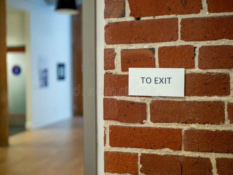 Zu Zeichen auf Backsteinmauer in einem modernen Lagerlobby-Bürobereich herausnehmen lizenzfreies stockbild Zu Zeichen auf Backsteinmauer in einem modernen Lagerlobby-Bürobereich herausnehmen lizenzfreies stockbild