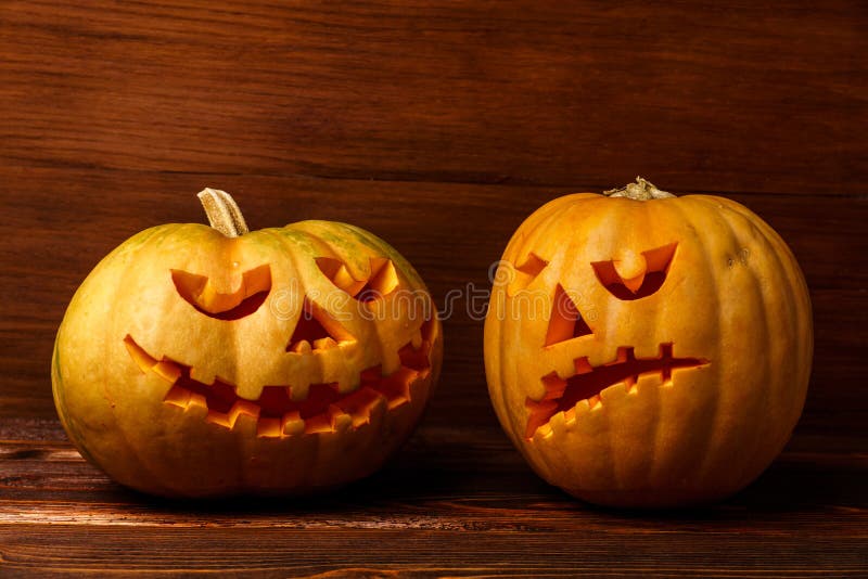 Zucche spaventose di Halloween su fondo di legno Scherzetto o dolcetto d'ardore spaventoso dei fronti Concetto della zucca di Hal immagini stock libere da diritti Zucche spaventose di Halloween su fondo di legno Scherzetto o dolcetto d'ardore spaventoso dei fronti Concetto della zucca di Hal immagini stock libere da diritti
