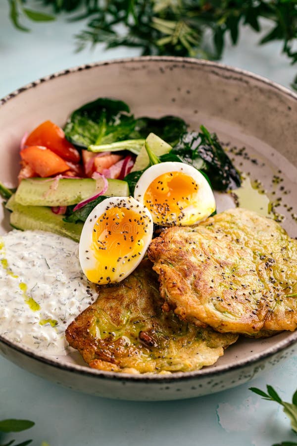 Zucchini Fritters with Eggs Sauces and Vegetables Stock Photo Image