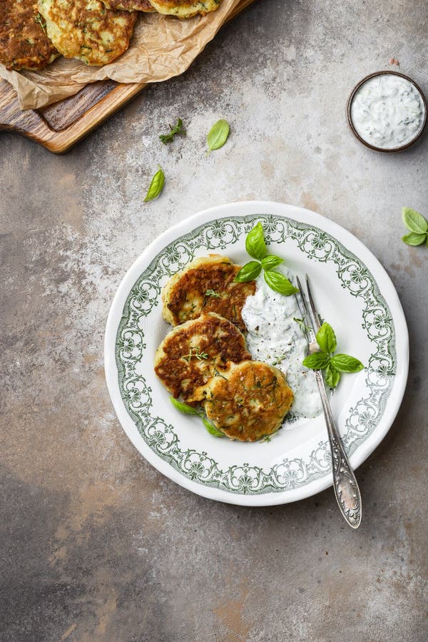 Zucchini und Parmesanfritter mit Tzatziki-Sauce lizenzfreies stockfoto