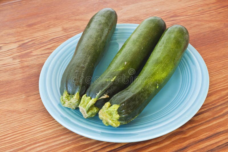 Zuchini on a turquoise plate and a table.