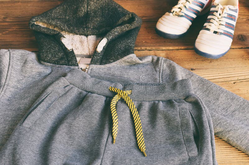Zuf?llige Ausstattung des Jugendlichen Jungenschuhe, -kleidung und -zus?tze auf h?lzernem Hintergrund - Strickjacke, Hose, Turnsc lizenzfreie stockbilder Zuf?llige Ausstattung des Jugendlichen Jungenschuhe, -kleidung und -zus?tze auf h?lzernem Hintergrund - Strickjacke, Hose, Turnsc lizenzfreie stockbilder