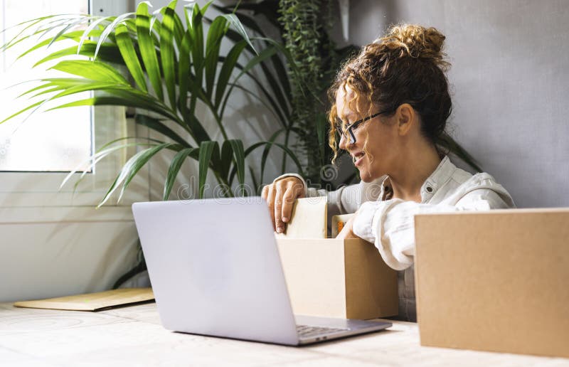 Zufriedene Frau, die das Paket und die Lieferung für ein neues Start-Business-Unternehmen vorbereitet. Tätigkeit. Mitarbeiter mit lizenzfreies stockbild