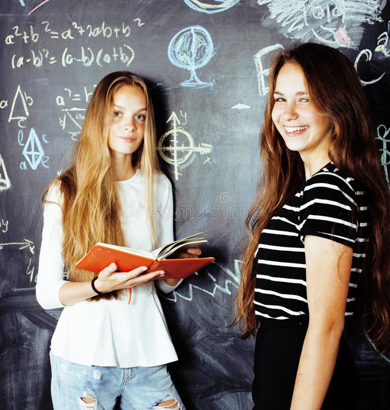 Zur?ck zu Schule nach Sommerferien, zwei jugendlich M?dchen im Klassenzimmer mit der Tafel zusammen gemalt lizenzfreie stockfotos Zur?ck zu Schule nach Sommerferien, zwei jugendlich M?dchen im Klassenzimmer mit der Tafel zusammen gemalt lizenzfreie stockfotos