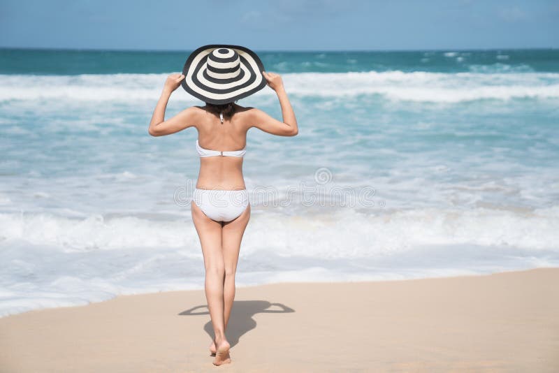 Zurück von der jungen Frau im Bikini, der auf dem Strand, junge schöne sexy Frau im Bikinibadeanzug, Tropeninsel, Sommer steht lizenzfreie stockfotografie Zurück von der jungen Frau im Bikini, der auf dem Strand, junge schöne sexy Frau im Bikinibadeanzug, Tropeninsel, Sommer steht lizenzfreie stockfotografie
