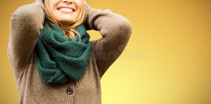 Beautiful blond woman with cap and scarf smiling against abstract yellow background. Beautiful blond woman with cap and scarf smiling against abstract yellow background