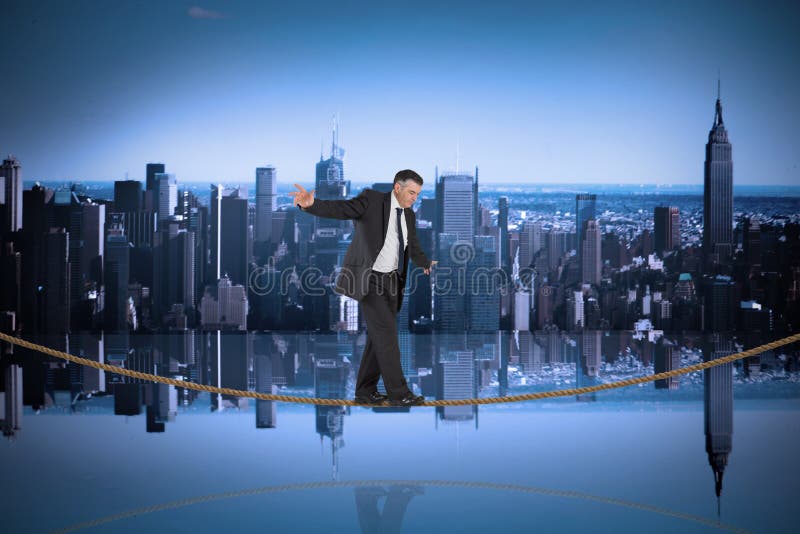 Zusammengesetztes Bild des reifen Geschäftsmannes einen Balanceakt auf Drahtseil tuend stockbild Zusammengesetztes Bild des reifen Geschäftsmannes einen Balanceakt auf Drahtseil tuend stockbild