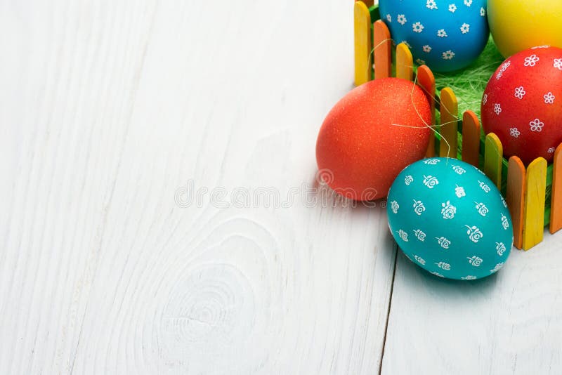 Zusammensetzung von Eiern für Ostern hinter einem bunten Zaun auf einem Holztisch lizenzfreie stockbilder Zusammensetzung von Eiern für Ostern hinter einem bunten Zaun auf einem Holztisch lizenzfreie stockbilder