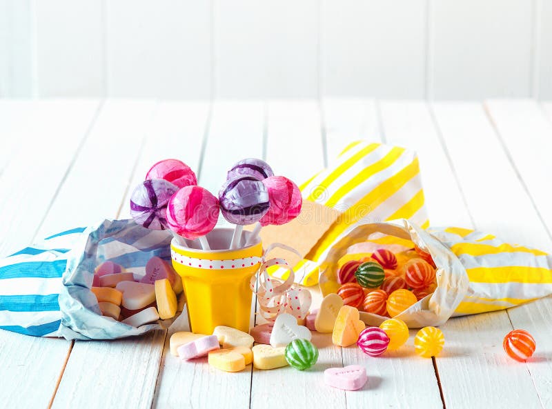 Zusammenstellung von Süßigkeiten in den Taschen und von Schale über einer Tabelle