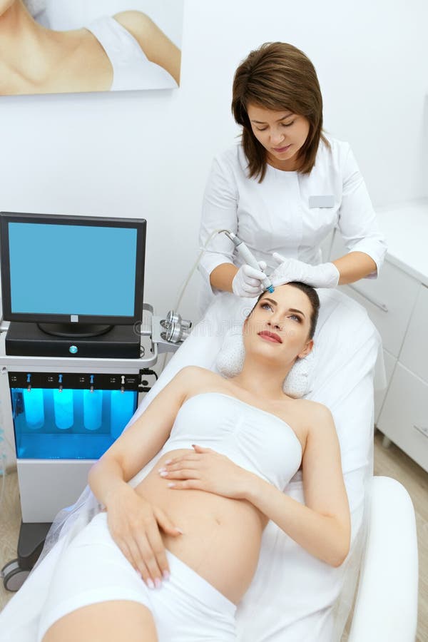 Hautpflege. Schwangere, die in der Schönheitsklinik Gesichtspflege betreiben