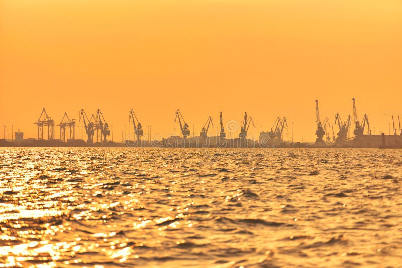 Zwaar industrieel havenmateriaal, grote kranen in zonsonderganglicht stock foto's Zwaar industrieel havenmateriaal, grote kranen in zonsonderganglicht stock foto's