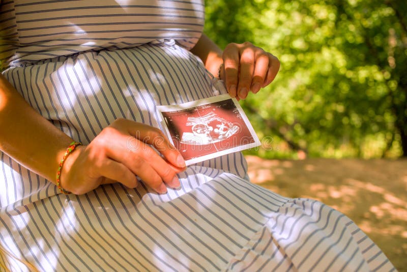 Zwanger de ultrasone klank sonogram beeld van de vrouwenholding Jong moederwachten van de baby stock fotografie Zwanger de ultrasone klank sonogram beeld van de vrouwenholding Jong moederwachten van de baby stock fotografie
