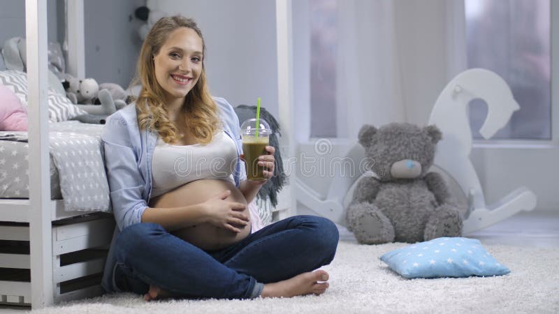 Zwanger wijfje met het groene smoothie glimlachen