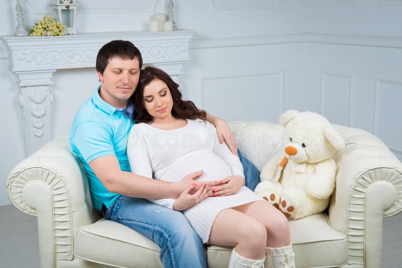 Zwangere familie, jong gelukkig paar die een baby verwachten stock fotografie Zwangere familie, jong gelukkig paar die een baby verwachten stock fotografie