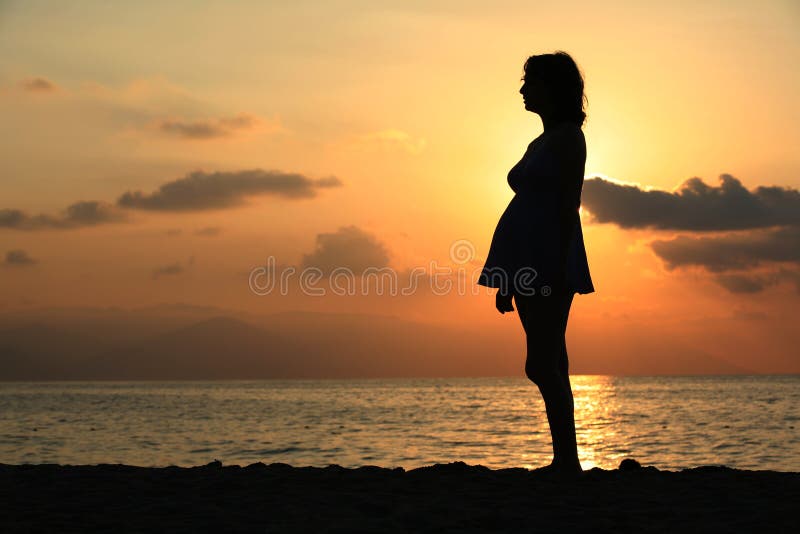 Zwangere vrouw bij zonsondergang royalty-vrije stock foto Zwangere vrouw bij zonsondergang royalty-vrije stock foto