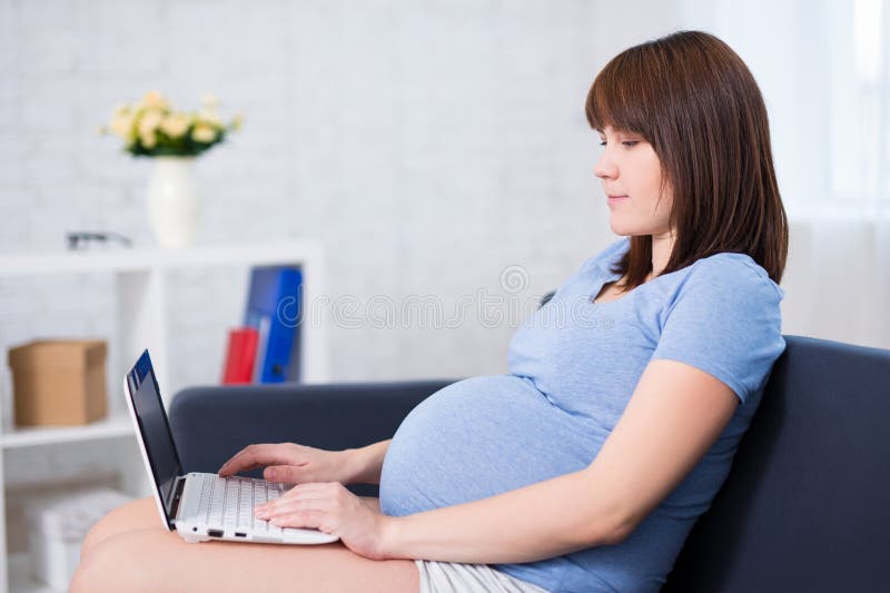 Zwangere vrouw die met laptop thuis werken royalty-vrije stock afbeelding Zwangere vrouw die met laptop thuis werken royalty-vrije stock afbeelding