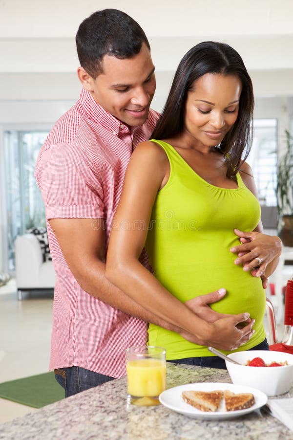 Zwangere Vrouw en Echtgenoot die Ontbijt in Keuken hebben
