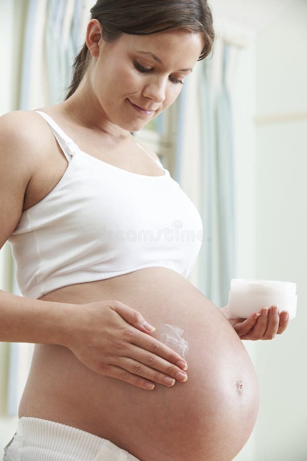 Zwangere Vrouwen Bevochtigende Buik stock foto Zwangere Vrouwen Bevochtigende Buik stock foto