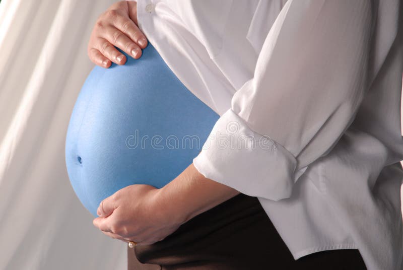 A pregnant woman's blue belly with her hands on it. A pregnant woman's blue belly with her hands on it.