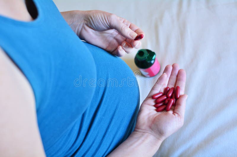 Zwangerschap - Zwangere vrouw die Geneeskunde nemen tijdens Zwangerschap stock fotografie Zwangerschap - Zwangere vrouw die Geneeskunde nemen tijdens Zwangerschap stock fotografie