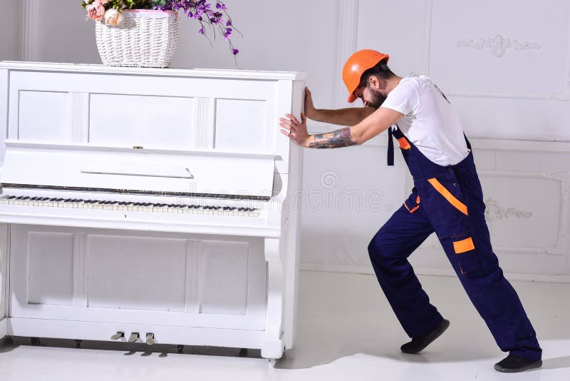 Zware ladingenconcept De lader beweegt pianoinstrument De koerier levert meubilair, beweging uit, verhuizing Mens met baard royalty-vrije stock afbeeldingen Zware ladingenconcept De lader beweegt pianoinstrument De koerier levert meubilair, beweging uit, verhuizing Mens met baard royalty-vrije stock afbeeldingen