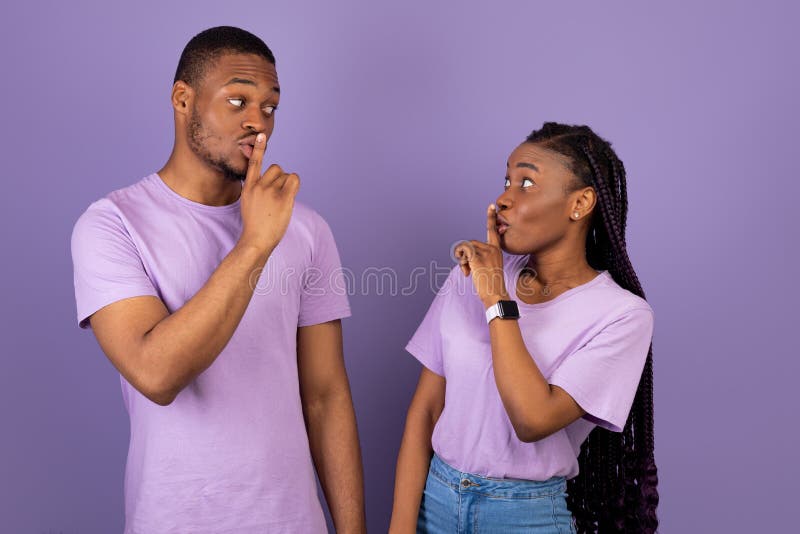 Shh, Keep Silence Concept. Cunning Black Couple Gesturing Hush Sign Posing Standing Isolated Over Purple Studio Wall, Looking At Each Other, Banner. Holding Finger On Lips, Silent Gesture, Secret. Shh, Keep Silence Concept. Cunning Black Couple Gesturing Hush Sign Posing Standing Isolated Over Purple Studio Wall, Looking At Each Other, Banner. Holding Finger On Lips, Silent Gesture, Secret