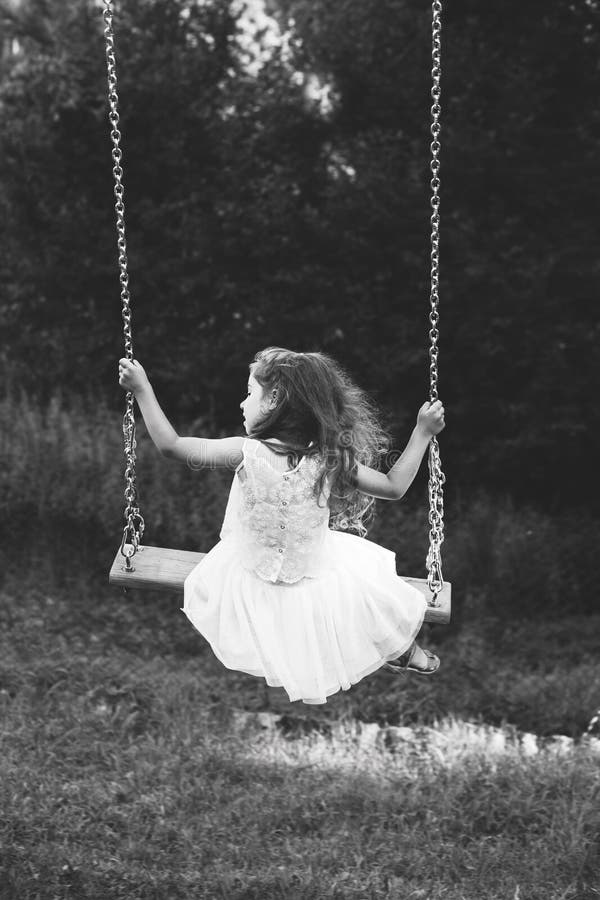 Zwart-wit portret van het leuke meisje glimlachen op schommeling bij de zomerdag, Gelukkig kinderjarenconcept royalty-vrije stock foto's Zwart-wit portret van het leuke meisje glimlachen op schommeling bij de zomerdag, Gelukkig kinderjarenconcept royalty-vrije stock foto's