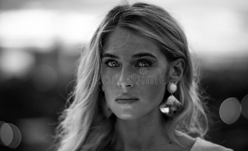 Zwart-wit Portret van mooi jong blonde in het turkooise overhemd op de achtergrond van de lichten van de nachtstad modern stock foto Zwart-wit Portret van mooi jong blonde in het turkooise overhemd op de achtergrond van de lichten van de nachtstad modern stock foto