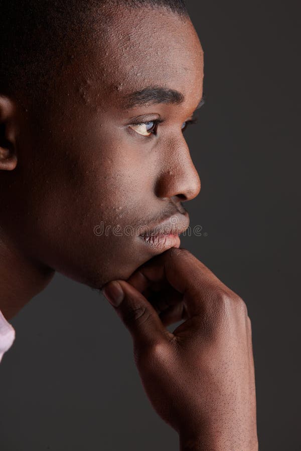 Young Adult black african businessman wearing a dark smart-casual outfit without a Jacket, but with a pink shirt and a dark waistcoat on a dark grey background in various poses with various facial expressions. Part of a series, Not Isolated. Single lightsource, hard shadows. Young Adult black african businessman wearing a dark smart-casual outfit without a Jacket, but with a pink shirt and a dark waistcoat on a dark grey background in various poses with various facial expressions. Part of a series, Not Isolated. Single lightsource, hard shadows