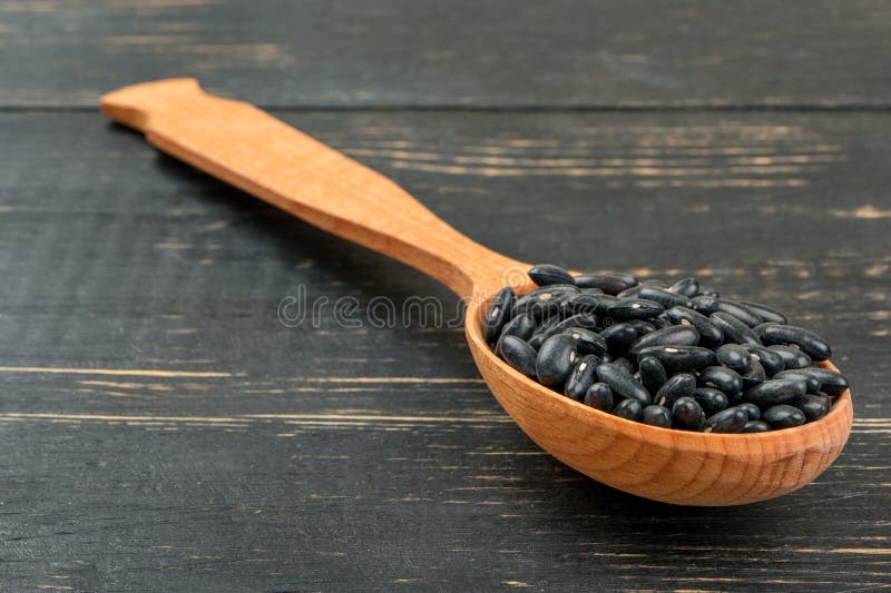Zwarte bonen in lepel stock fotografie