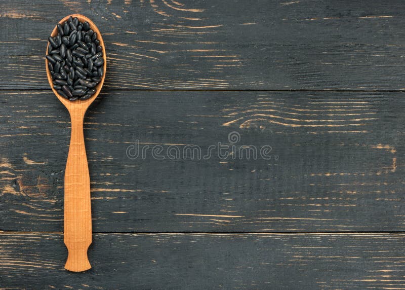 Zwarte bonen in lepel stock foto's