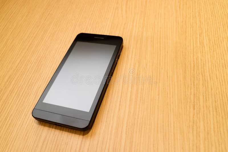 Zwarte smartphone op houten lijstachtergrond met exemplaarruimte voor royalty-vrije stock afbeelding Zwarte smartphone op houten lijstachtergrond met exemplaarruimte voor royalty-vrije stock afbeelding
