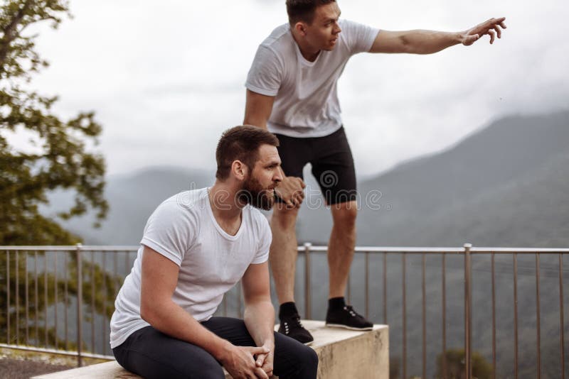 Zwei Athleten stehen nach intensivem Trainingstraining im Freien in der Berglandschaft still stockfotos Zwei Athleten stehen nach intensivem Trainingstraining im Freien in der Berglandschaft still stockfotos