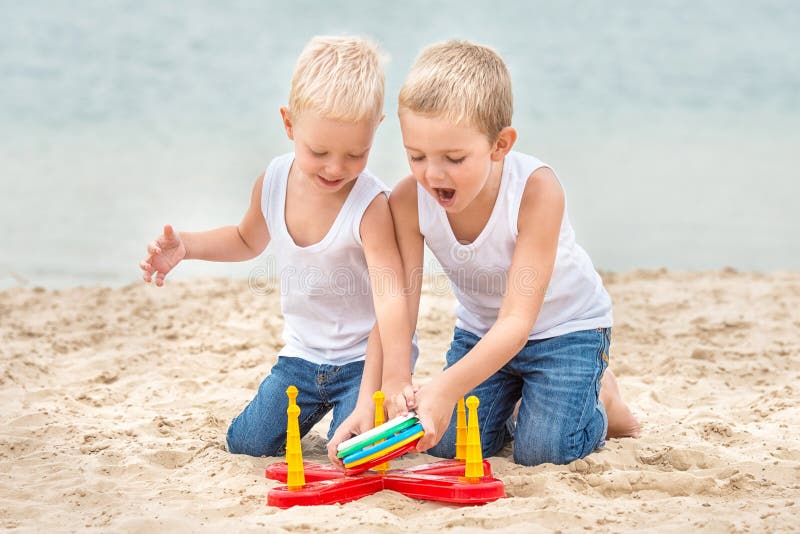 Zwei Brüder sind, spielend gehend und auf dem Strand Das Spiel ist ein Ringwurf stockbild Zwei Brüder sind, spielend gehend und auf dem Strand Das Spiel ist ein Ringwurf stockbild
