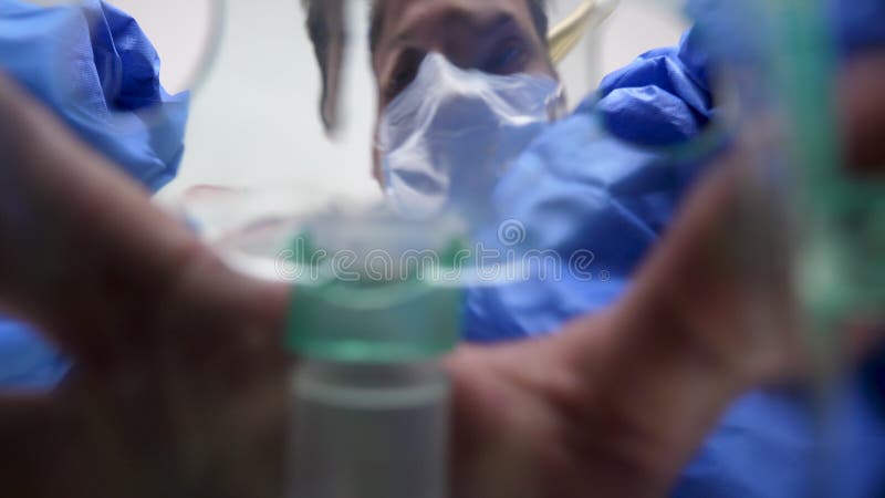 Zwei Chirurgen, die eine Sauerstoffmaske über einem Patienten setzen stock footage