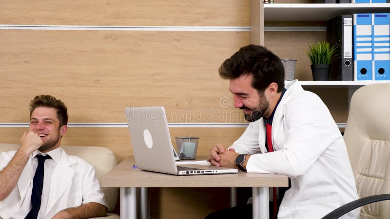 Zwei Doktoren im Büro, das beginnt zu lachen stock footage