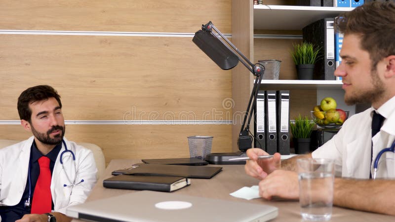 Zwei Doktoren im Büro, das ein angenehmes Gespräch hat stock video footage