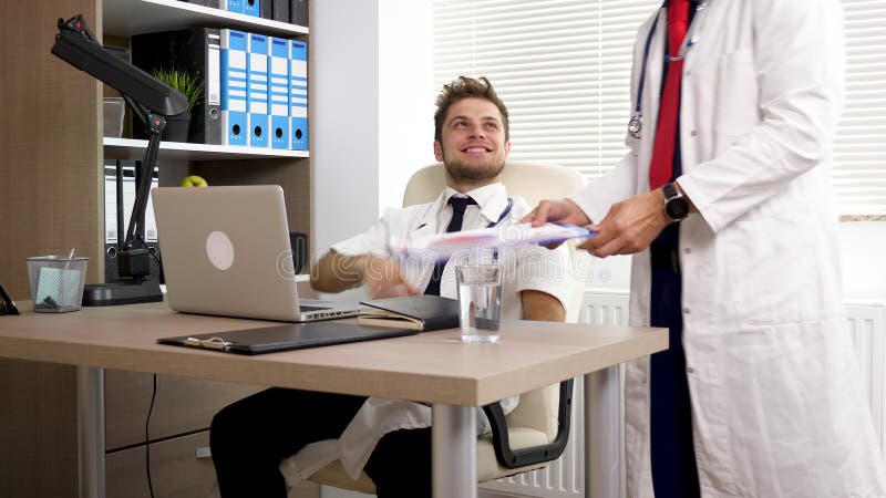 Zwei Doktoren treffen sich in einem Büroraum im Krankenhaus und rütteln Hände stock footage