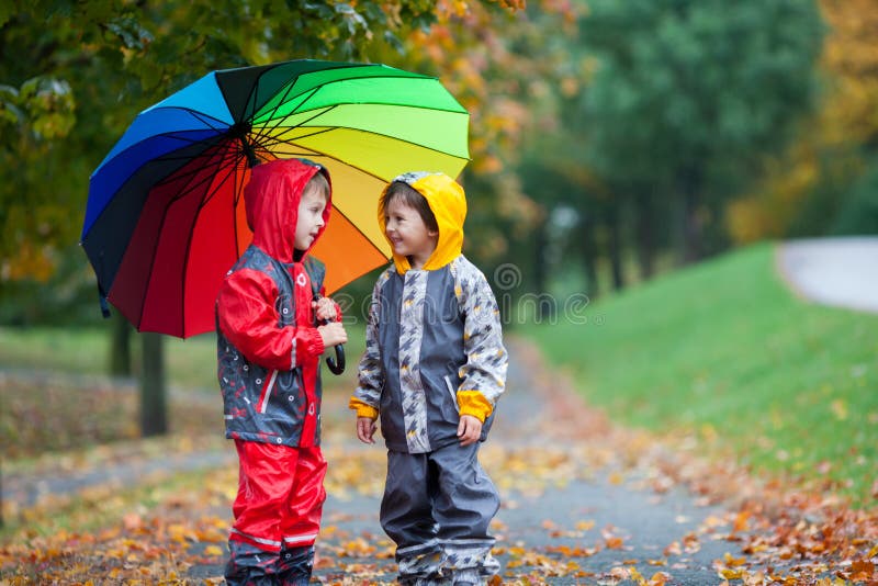 Zwei entzückende Kinder, Jungenbrüder, spielend im Park mit umbrel lizenzfreie stockfotografie Zwei entzückende Kinder, Jungenbrüder, spielend im Park mit umbrel lizenzfreie stockfotografie