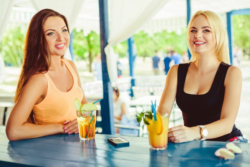 Zwei Freundinnen, die den Spaß im Freien im Sommer haben Frauen mit Gläsern des Cocktails im Urlaub stockfotos Zwei Freundinnen, die den Spaß im Freien im Sommer haben Frauen mit Gläsern des Cocktails im Urlaub stockfotos