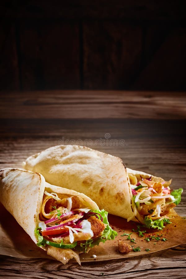 Zwei geschmackvolle doner Kebabs mit rustikalem Kopienraum lizenzfreie stockbilder Zwei geschmackvolle doner Kebabs mit rustikalem Kopienraum lizenzfreie stockbilder