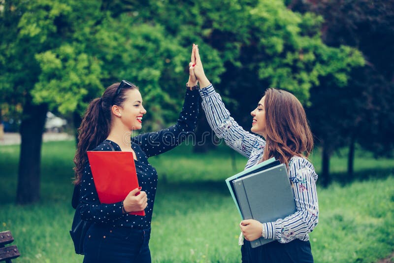 Zwei gl?ckliche Studentinnen geben hoch f?nf, nach erfolgreich lernen lizenzfreies stockfoto Zwei gl?ckliche Studentinnen geben hoch f?nf, nach erfolgreich lernen lizenzfreies stockfoto