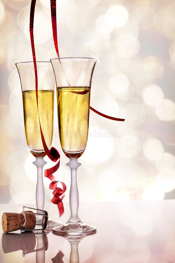 Zwei Gläser funkelndes Weißwein und Korken auf Tabelle lizenzfreie stockfotos
